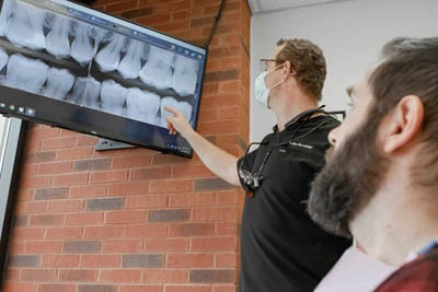 dentist showing patient restorative dentistry x-ray on screen