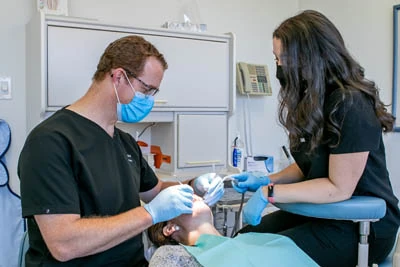 patient in dental chair receiving a teeth whitening
